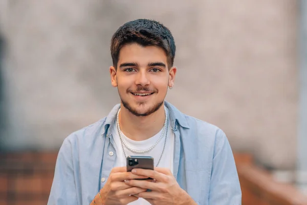 Młody Człowiek Patrząc Telefon Komórkowy Ulicy — Zdjęcie stockowe