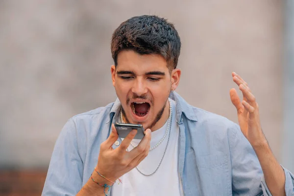 Wściekły Młody Człowiek Krzyczący Przez Telefon Komórkowy Domu — Zdjęcie stockowe