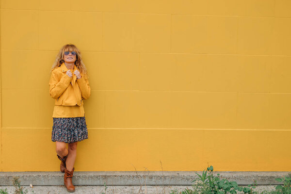 middle aged woman isolated on yellow wall