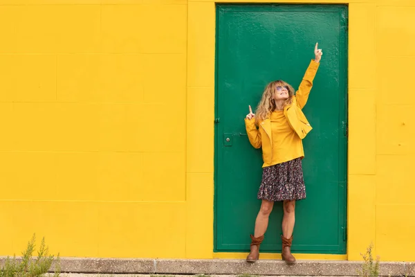Счастливая Женщина Средних Лет Зеленой Двери Желтой Стеной — стоковое фото
