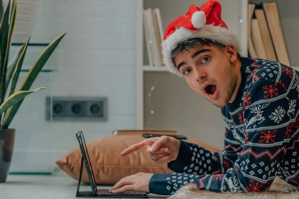 クリスマスに家でコンピュータと驚きの表情で若者が — ストック写真