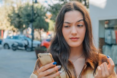 Cep telefonu ve güvensizlik veya şüphe ifadesi olan bir kadın.