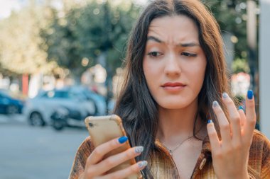 Cep telefonu ve güvensizlik veya şüphe ifadesi olan bir kadın.