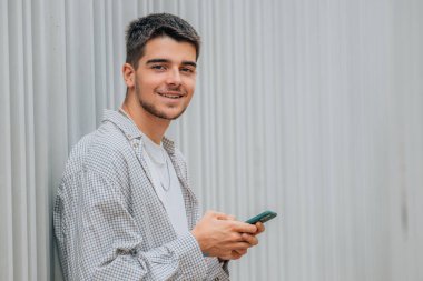 Sokaktaki cep telefonlu genç adamın portresi.