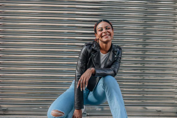 stock image black girl smiling at the metal door of the street