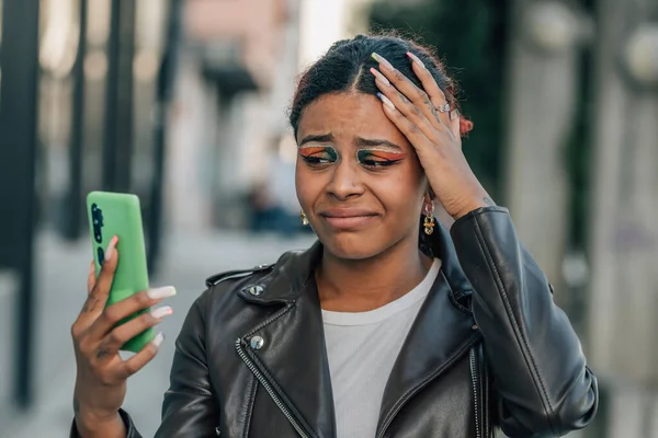 stock image woman with mobile phone in the street and expression of resignation