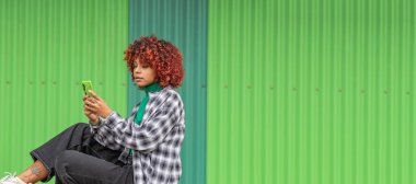 girl with mobile phone in the street on green background