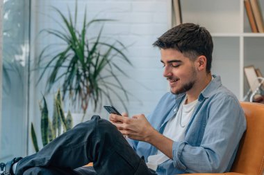 Evde cep telefonu olan genç bir adam ya da öğrenci