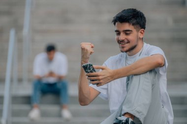 young urban millennial with successful expression looking at mobile phone