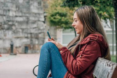 young man or student in the park with mobile phone