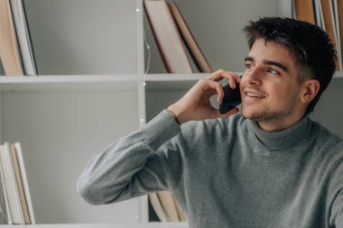 young man at home with mobile phone or smartphone