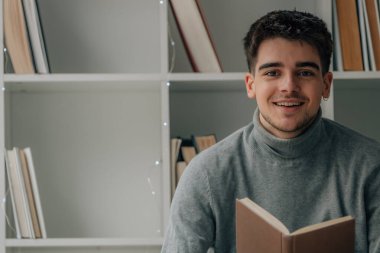 young man at home reading a textbook