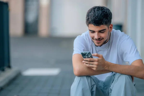 young man on the street looking at the phone or smartphone