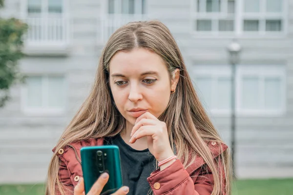 Zamyślona Dziewczyna Ulicy Patrząc Telefon Komórkowy — Zdjęcie stockowe