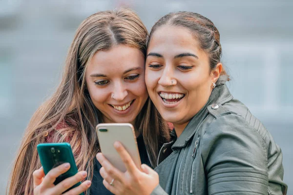 Přátelé Mobilními Telefony Usmívají Objímání Ulici — Stock fotografie