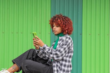 girl with mobile phone in the street on green background