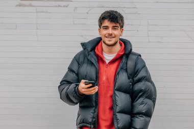 boy with phone on the street in warm clothes