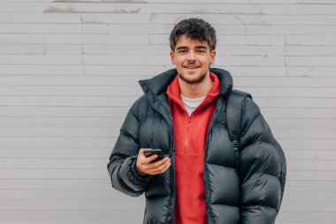 boy with phone on the street in warm clothes