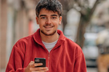 Sokakta cep telefonu olan bir çocuk.