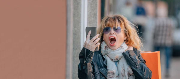 Женщина Среднего Возраста Мобильным Телефоном Сумками Удивленным Выражением Лица — стоковое фото