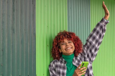 Cep telefonlu Latin Amerikalı kız mutlu kutluyor.