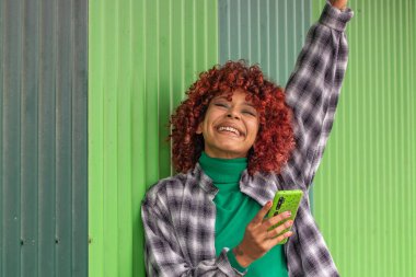 Cep telefonlu Latin Amerikalı kız mutlu kutluyor.