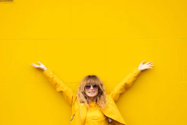 中年女性Elated上の喜びとともに黄色の壁屋外 — ストック写真