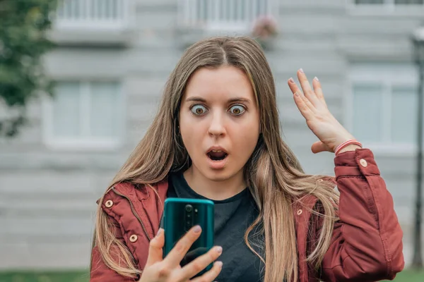 Chica Con Expresión Sorprendida Mirando Teléfono Celular Teléfono Móvil Calle —  Fotos de Stock