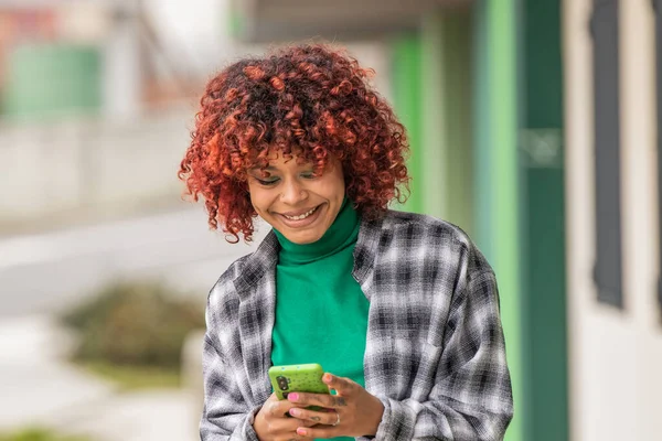 stock image afro girl in the street with mobile phone