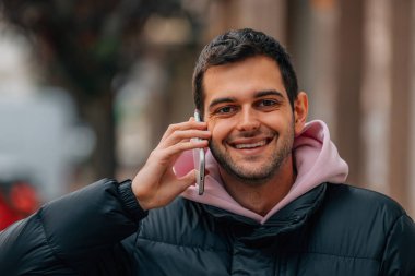 Sokakta telefonla konuşan sıradan bir genç adam portresi.
