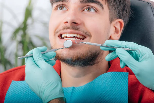 牙科医生和病人手拿着工具在诊所里 — 图库照片