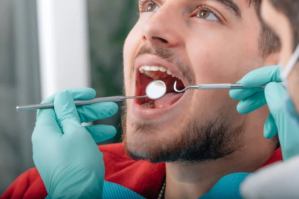 dentist working with tools in patient\'s mouth
