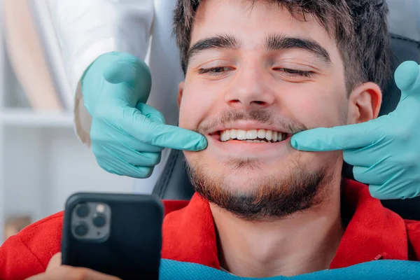 Pacjent Dentysty Patrzący Telefonem Komórkowym — Zdjęcie stockowe