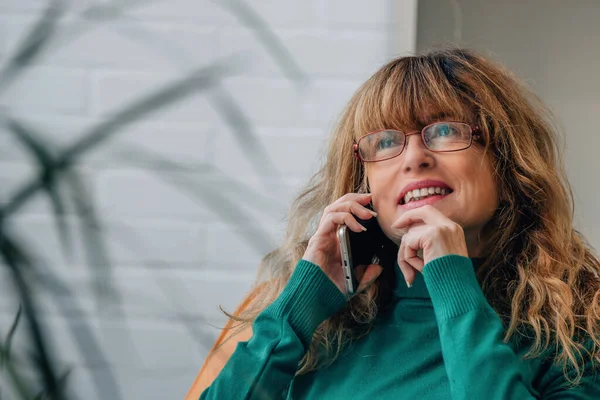 stock image pretty middle-aged woman talking on mobile phone at home