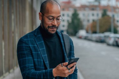 Adam sokakta cep telefonuna bakıyor.