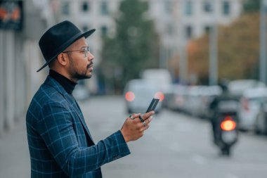 Şehir caddesinde cep telefonu olan Latin Amerikalı adam.