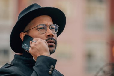 Sokakta telefonla konuşan Latin bir adam.