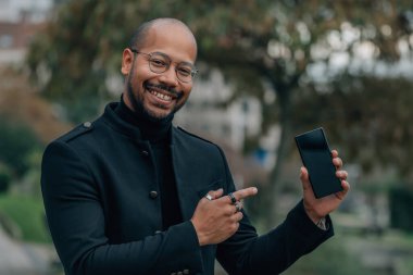 Adam sokakta cep ya da cep telefonuna bakıyor.