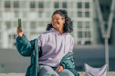 şehir kızı cep telefonuyla fotoğraf çekiyor.