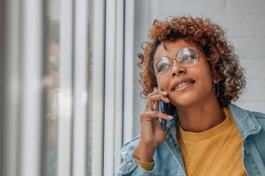 Kız içeride cep telefonuyla konuşuyor.