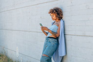 Sokakta cep telefonu olan Latin Afrikalı Amerikalı kız.