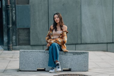 Sokakta bankta oturan genç bir kız