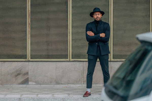 latino man with hat on the street waiting standing