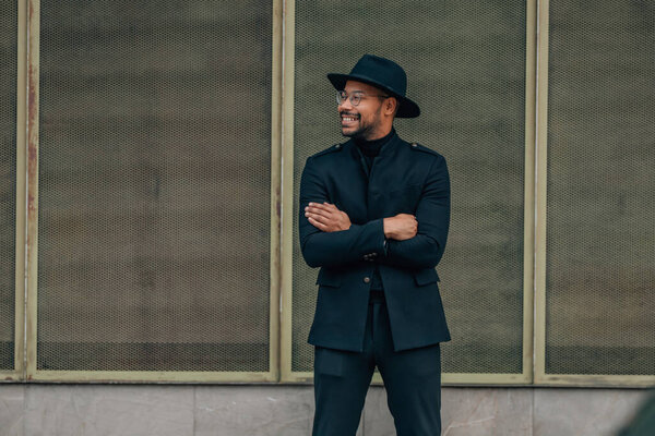 latino man with hat on the street waiting standing