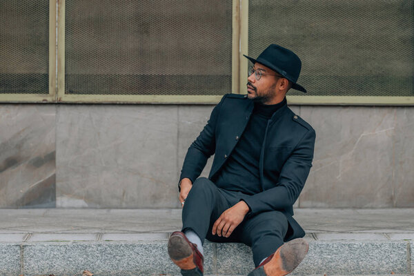 man in the street sitting on the sidewalk