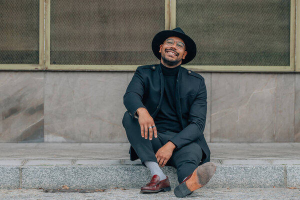 man in the street sitting on the sidewalk