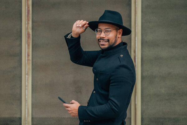 man on the city street waving with mobile phone
