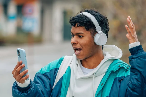 Ung Man Med Hörlurar Och Mobiltelefon Med Överraskande Uttryck — Stockfoto