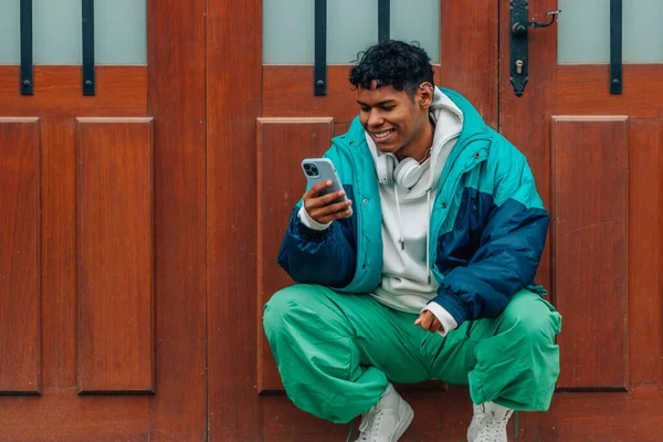 城市里的年轻拉蒂诺男人在街上拿着手机 — 图库照片