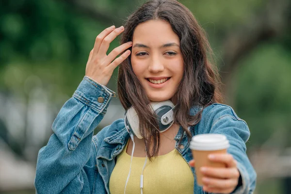 Νεαρή Κοπέλα Στο Δρόμο Φλιτζάνι Καφέ Και Ακουστικά — Φωτογραφία Αρχείου